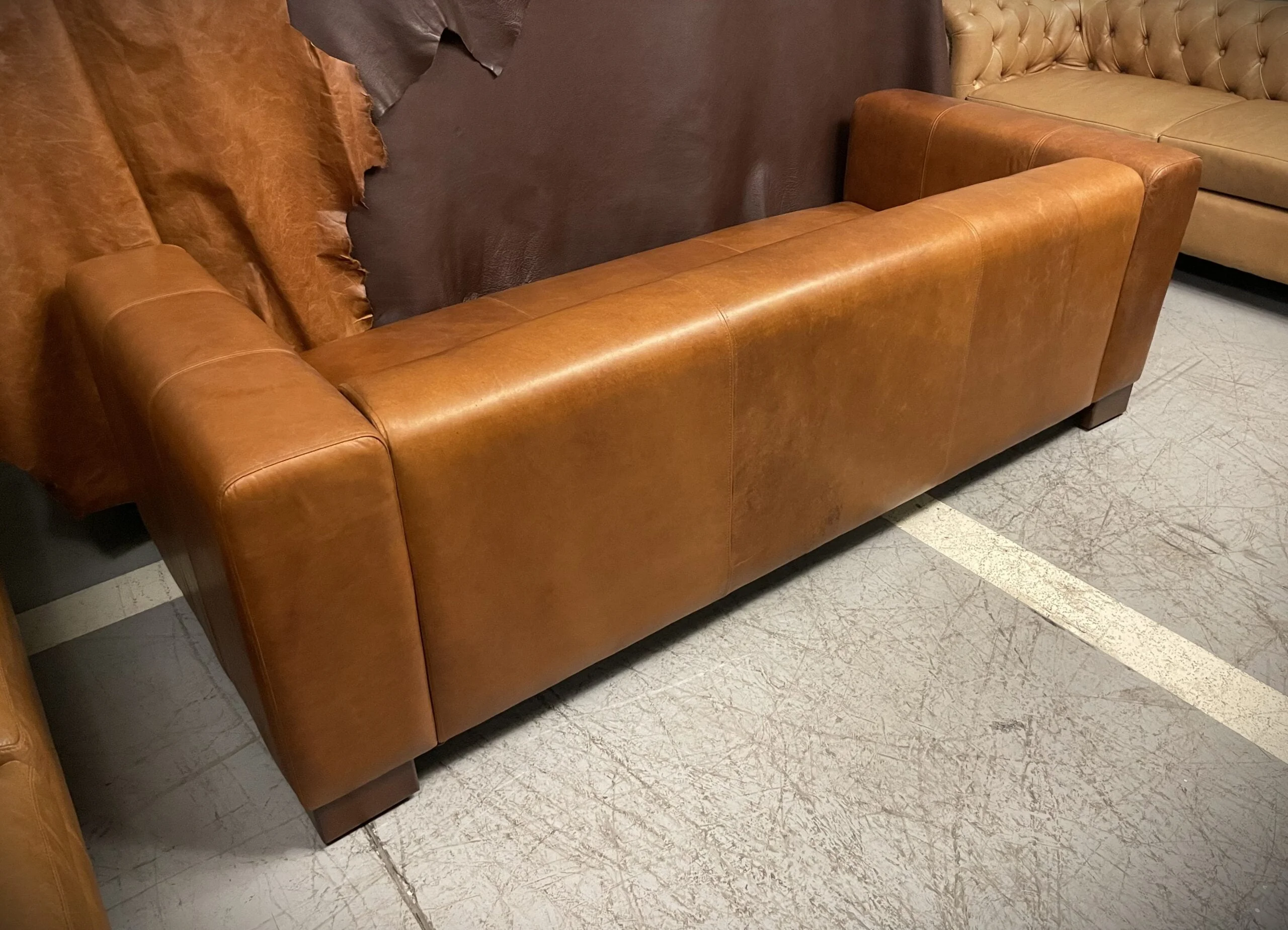 Sofá de Cuero - Tenor, Costura cargada simple y doble en asiento, brazos, respaldo y trasera, Patas de madera en L 10cm, Color cuero Rustic Terra, Cuero 100% Natural Uruguayo.