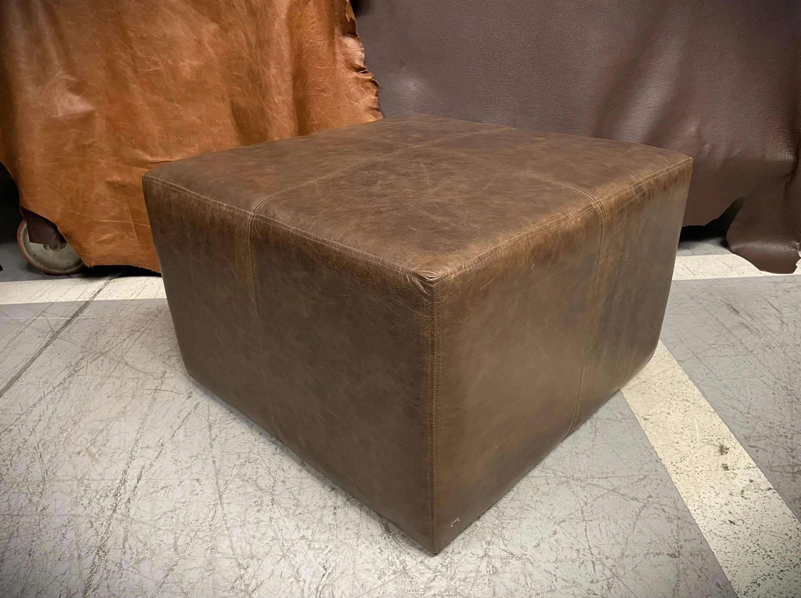 Pouf de Cuero – Tenor, Costura Cargada Simple y Doble, Color Riga Mocassine, 70x70x45cm, Cuero 100% Natural Uruguayo.