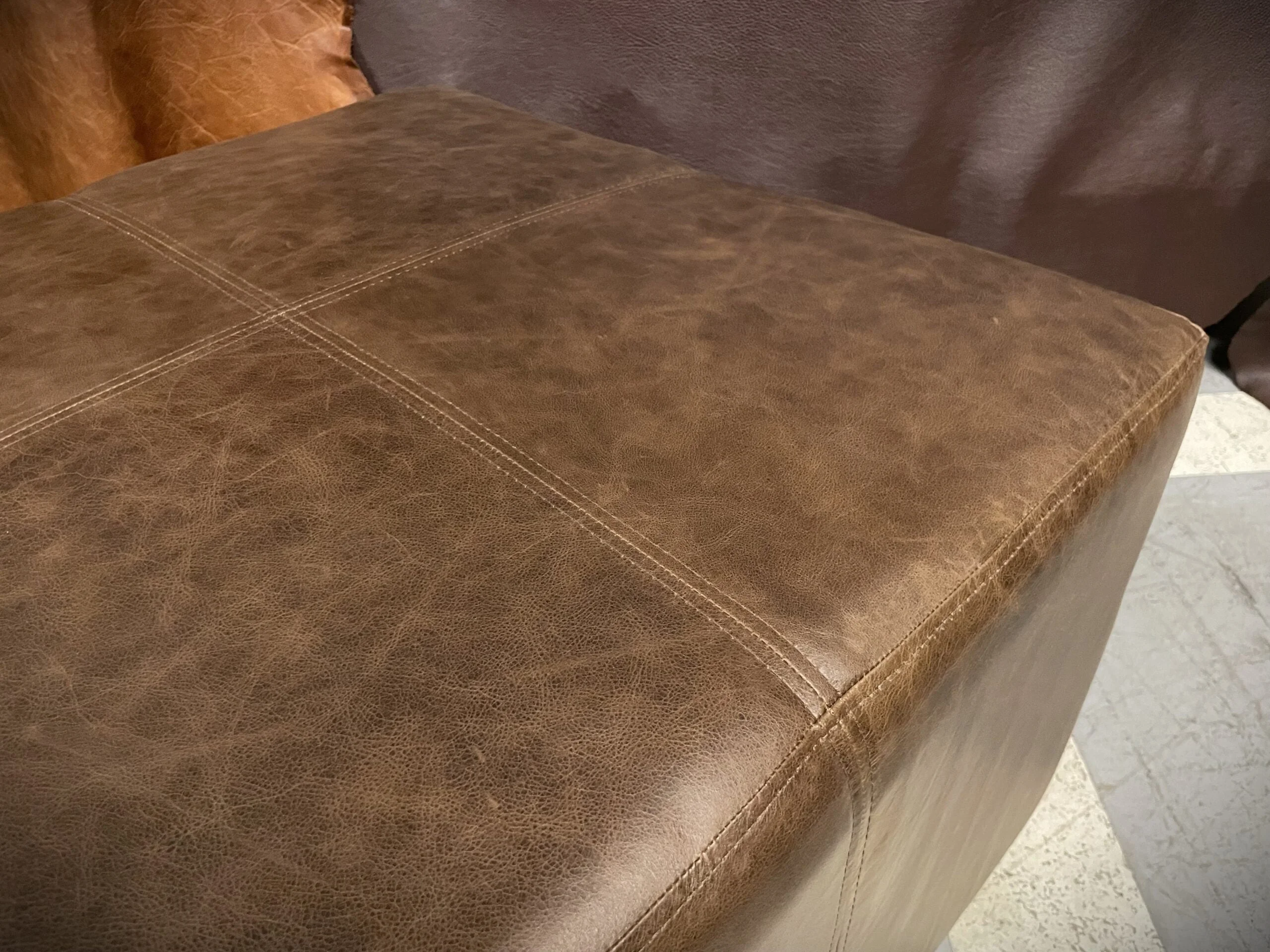 Pouf de Cuero – Tenor, Costura Cargada Simple y Doble, Color Riga Mocassine, 70x70x45cm, Cuero 100% Natural Uruguayo.