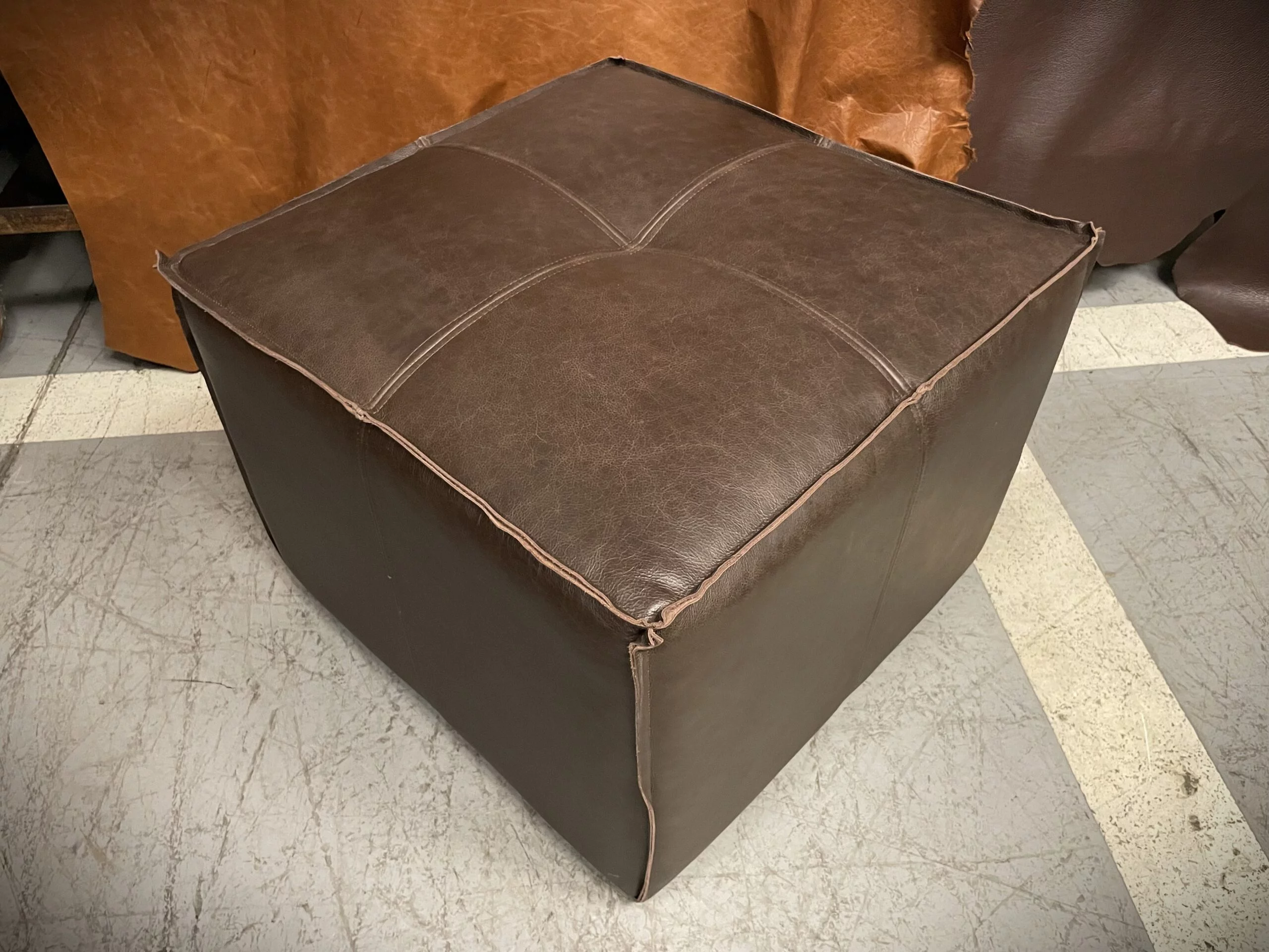 Pouf de Cuero – Tenor, Costura tipo pestaña, Color Riga Chocolate, 60x60x45cm, Cuero 100% Natural Uruguayo.